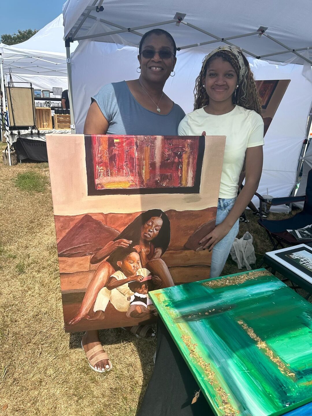 Two buyers holding the Roots painting with Aniya at a gallery